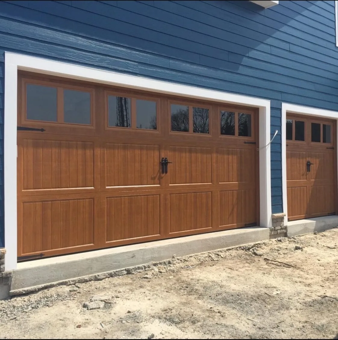 new brown garage door with blue house