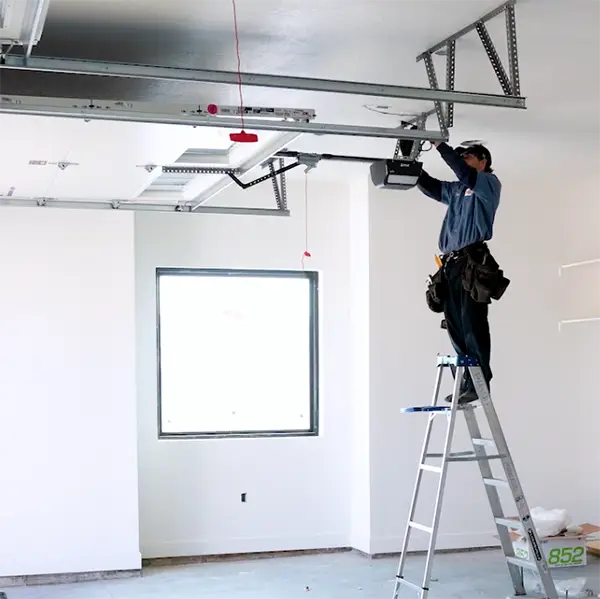Technician standing on a ladder working on the garage door opener