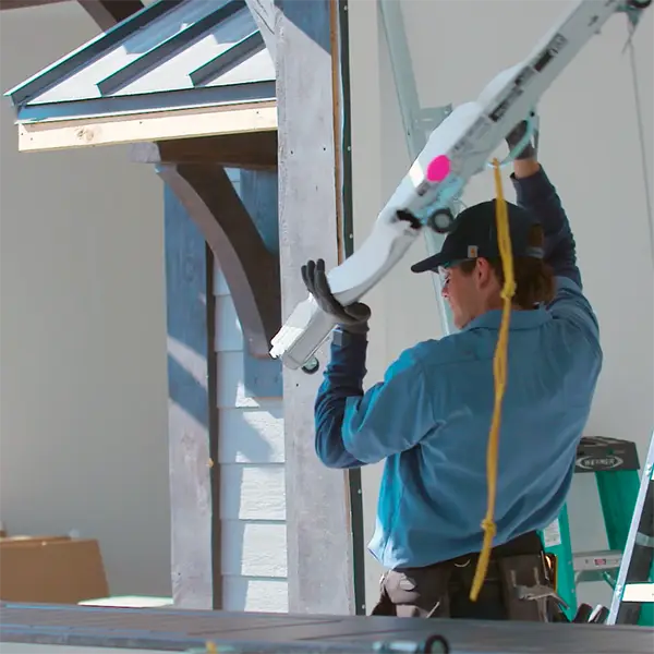 Technician carrying a new garage door panel during installation