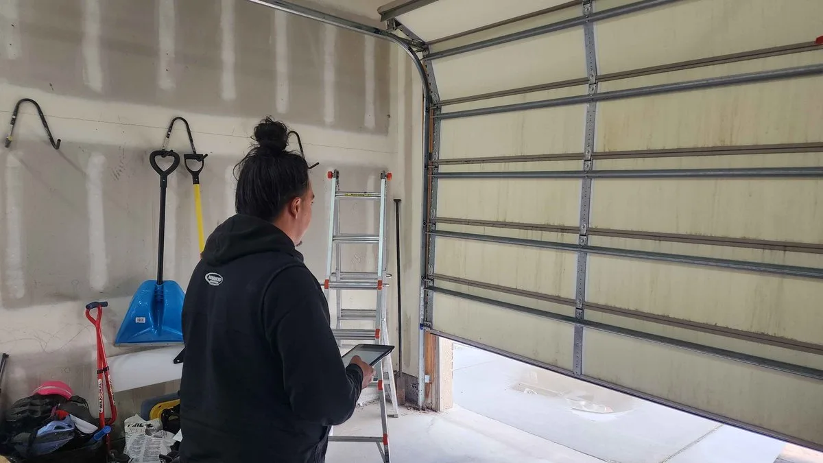 Homeowner comparing multiple garage door repair estimates on a table
