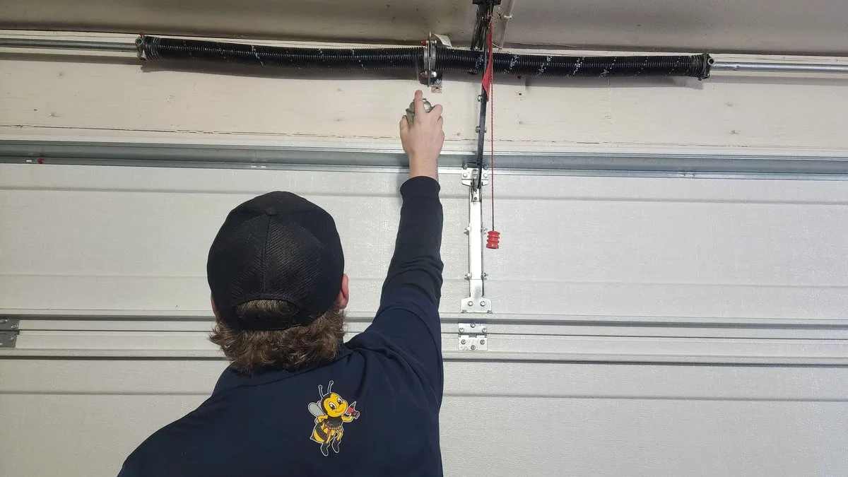 Garage Door Tune-Up: What's Included, What It Costs, and Why Utah Homeowners Need One Technician performing a garage door tune-up and maintenance inspection