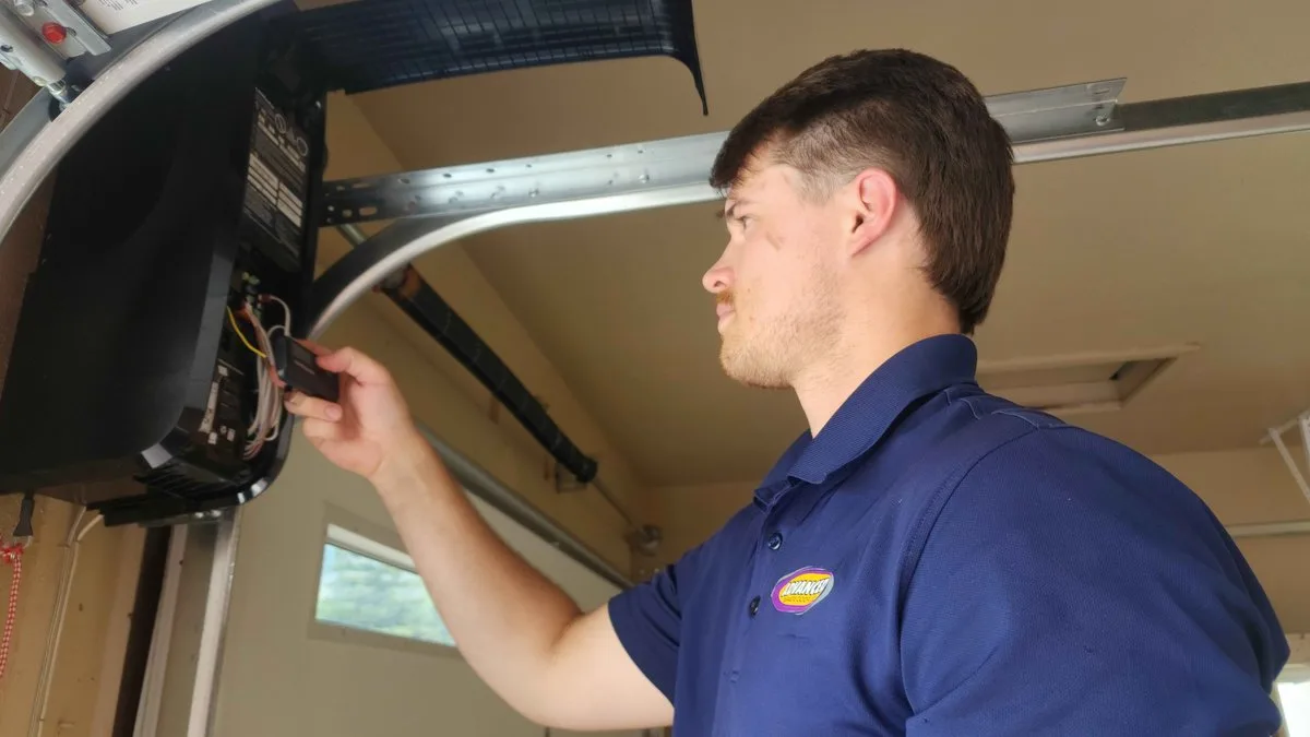 How to Reset a Garage Door Opener: Complete Guide for Utah Homeowners Homeowner pressing the reset button on a garage door opener motor unit