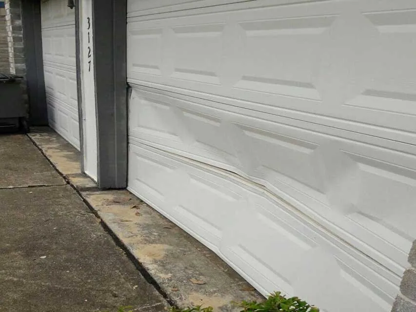 Garage Door Wind Load Ratings: What Utah Homeowners Need to Know (2026 Guide) Wind-damaged garage door panels showing structural damage